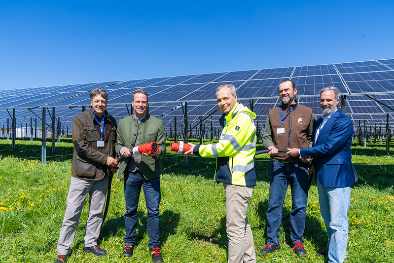 Personen stehen vor der Agri PV Anlage zur offiziellen Eröffnung