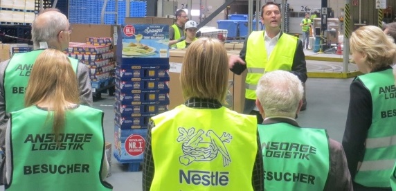 Ein Nestlé Manager führt Besucher durch das Werk