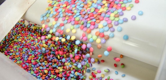 Viele bunte SMARTIES laufen über das Fließband