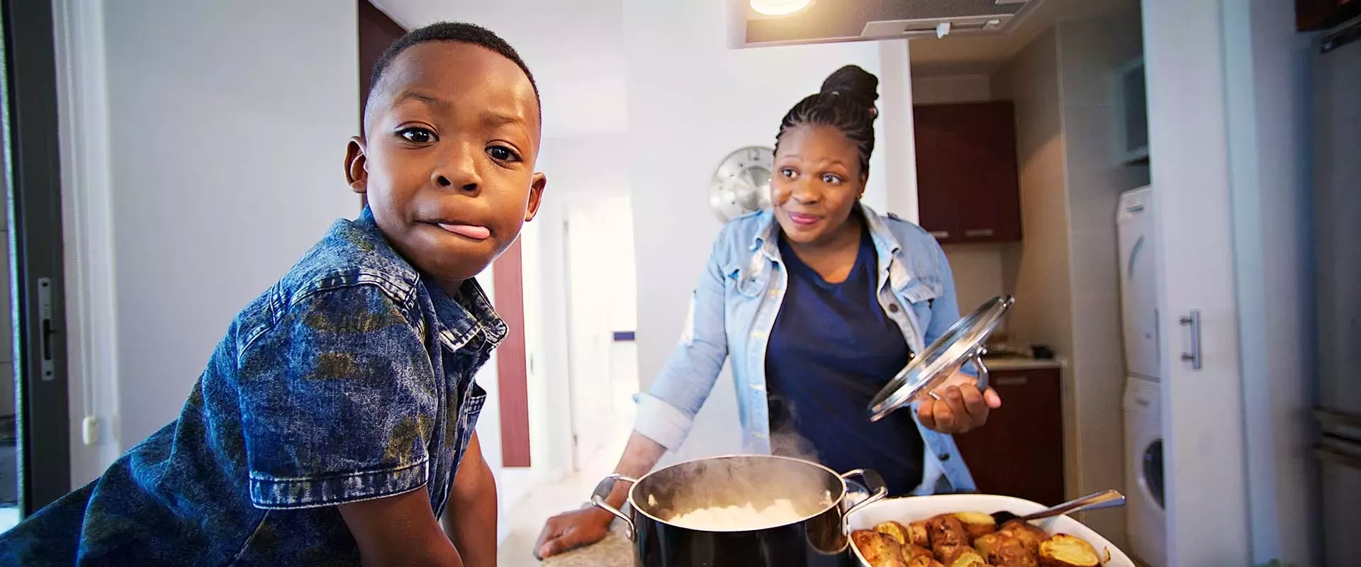 Kind und Elternteil in der Küche beim Kochen