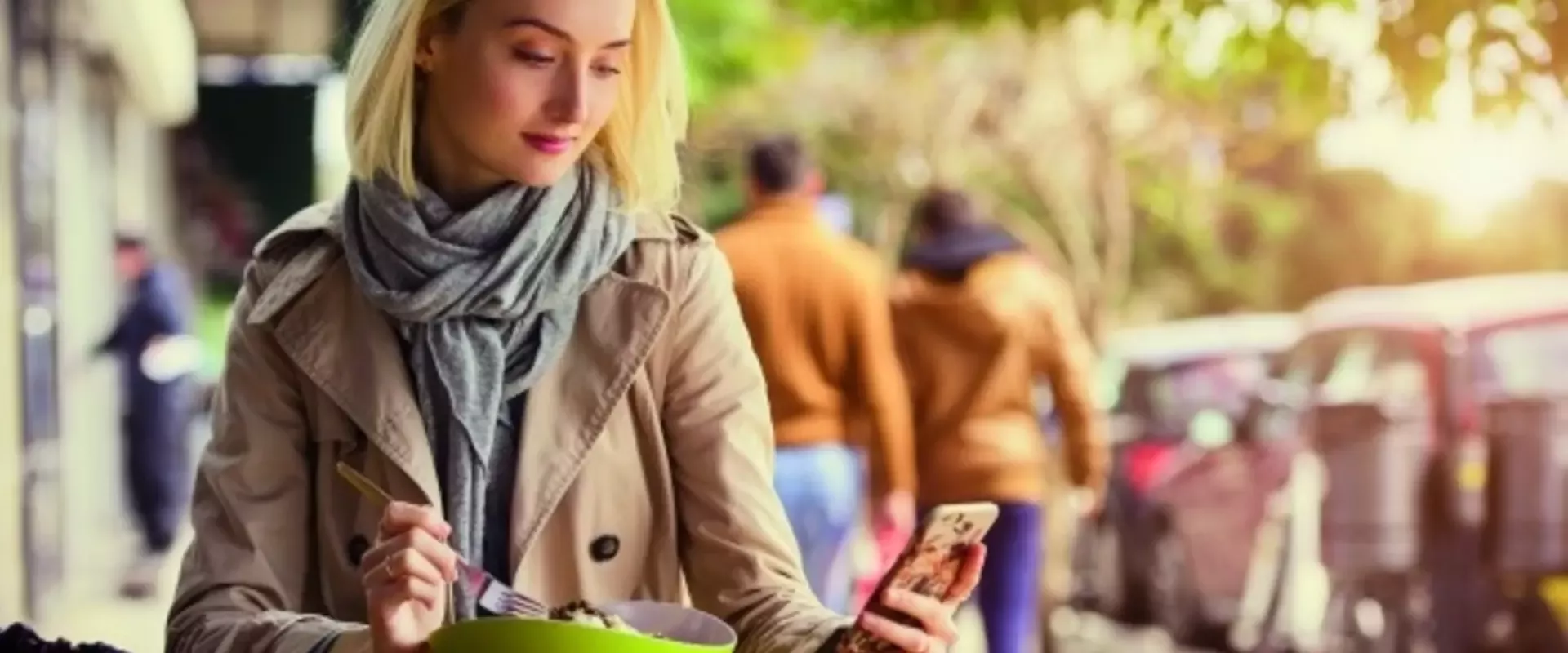 Frau schaut beim essen auf ihr Handy