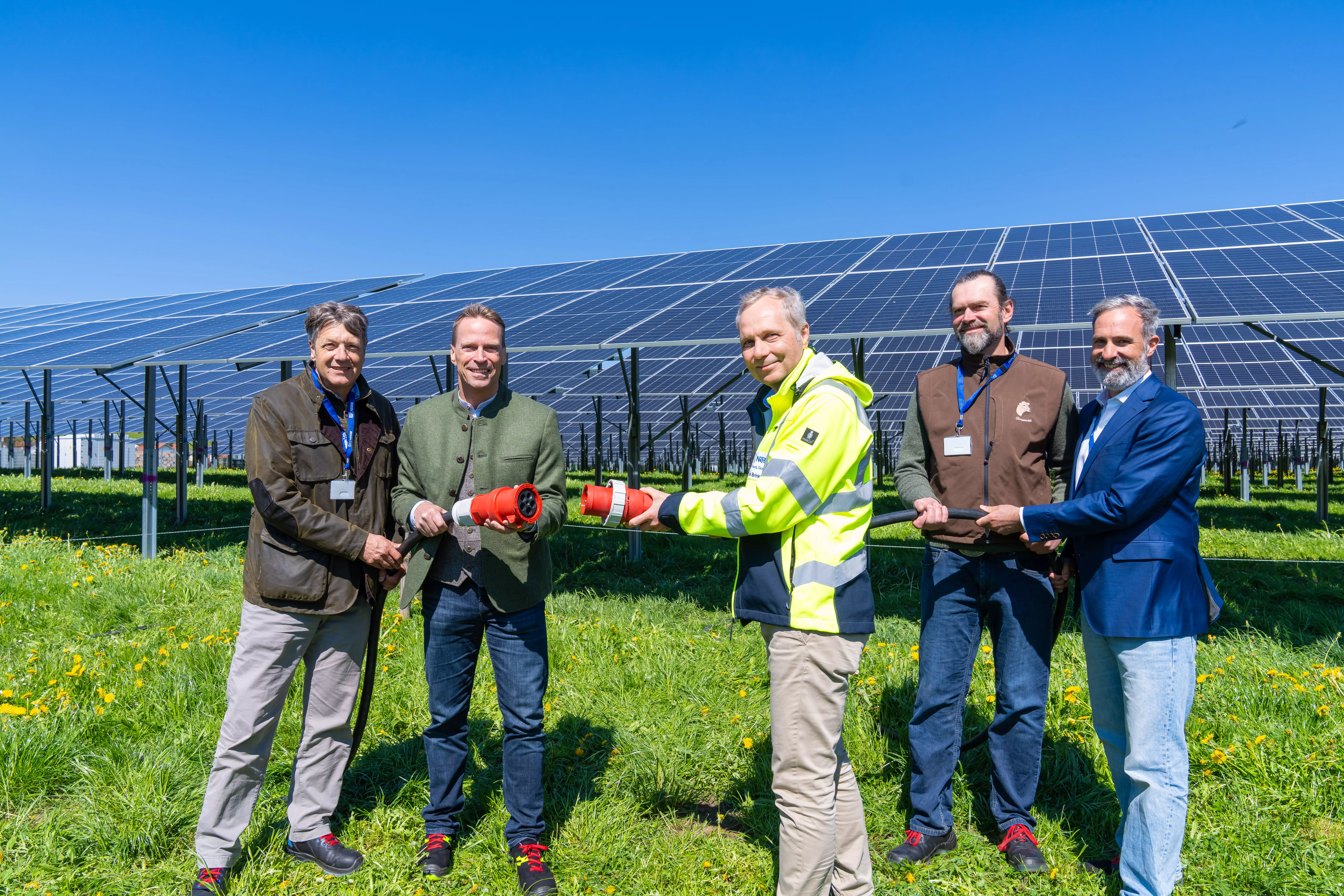 Personen halten Stecker für Agri-Photovoltaic-Anlage