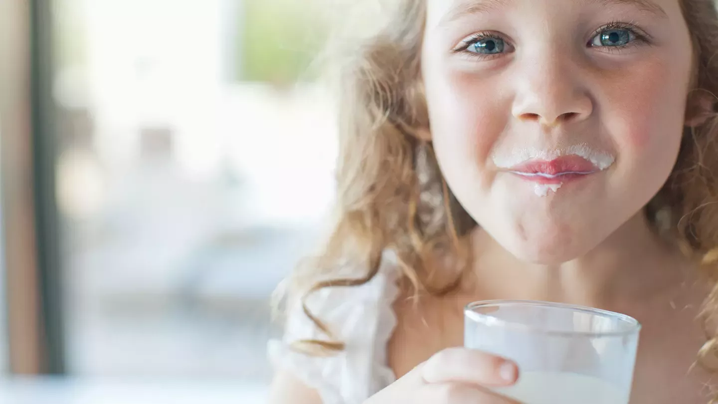 Mädchen mit Milchrand um den Mund